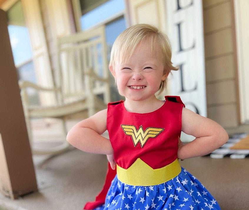 A little girl wearing a Wonder Woman dress made for her as she battles cancer.